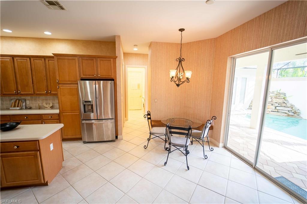 5886 Paradise Circle Naples, FL 34110 - Photo 6 of 19 a kitchen with a refrigerator a sink and a stove top oven