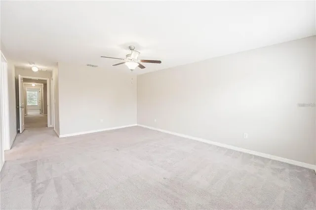 an empty room with a ceiling fan and a window