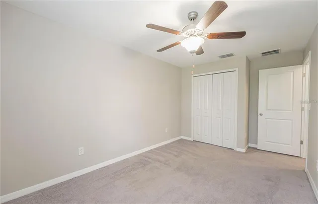 an empty room with chandelier fan