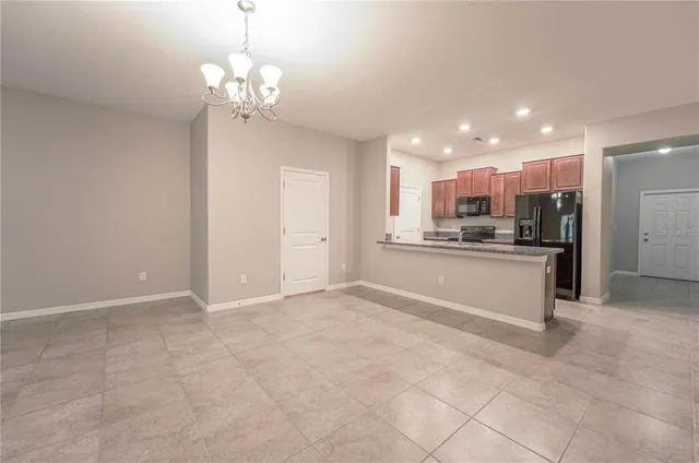 a view of kitchen with refrigerator and cabinets