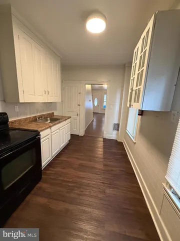 a view of a kitchen with wooden floor and electronic appliances