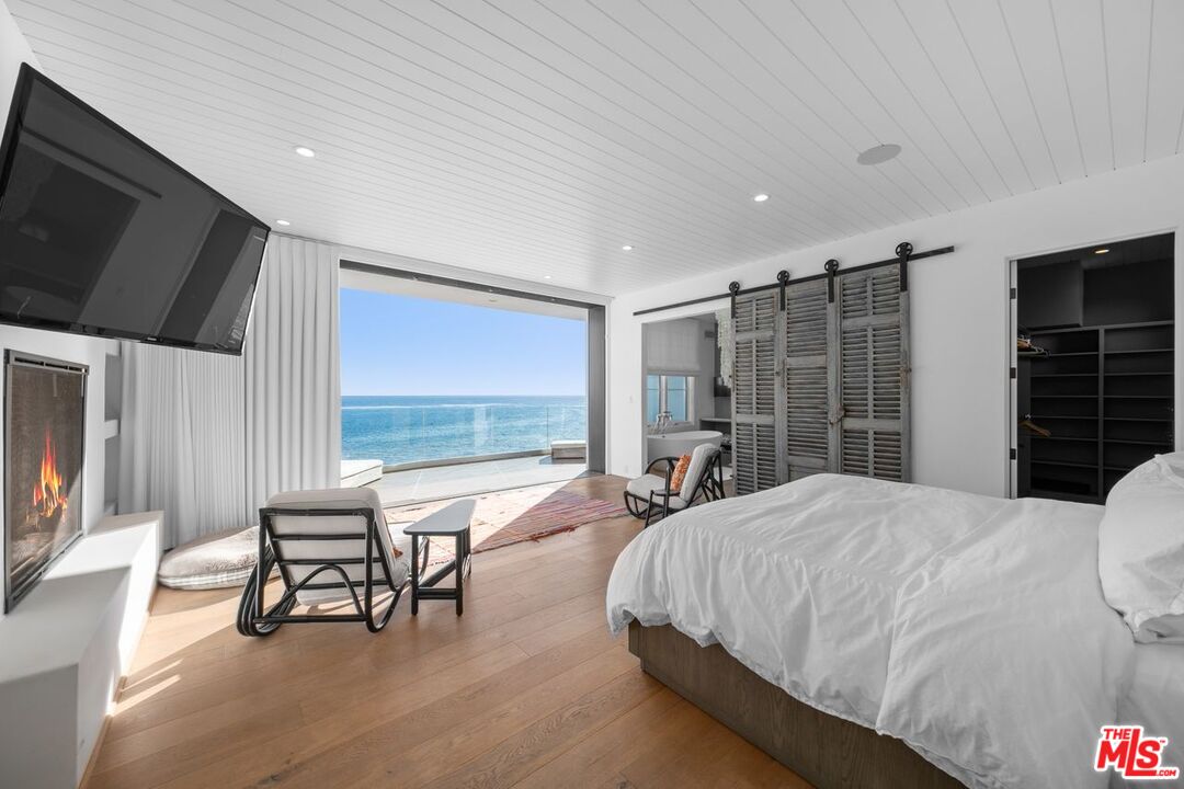 27212 Escondido Beach Road Malibu, CA 90265 - Photo 14 of 35 a spacious bedroom with a bed and large windows