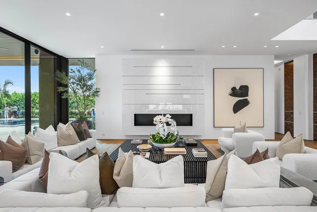 a living room with fireplace furniture and a large window