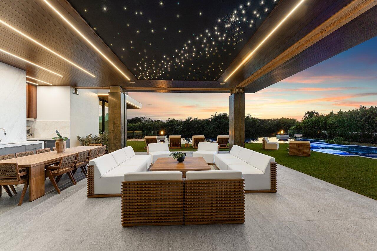 126 Spinnaker Lane Jupiter, FL 33477 - Photo 4 of 96 a living room with patio furniture and a garden