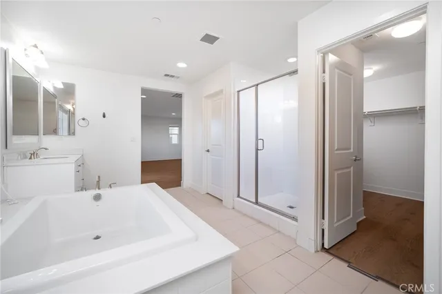 a bathroom with a double vanity sink a mirror and a bathtub