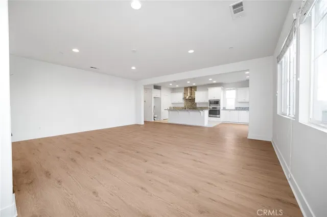 a view of large kitchen with wooden floor and windows