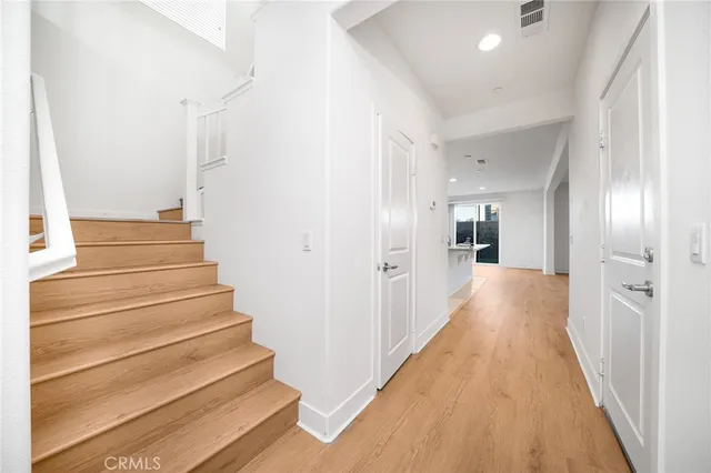 a view of a hallway with wooden floor and stairs