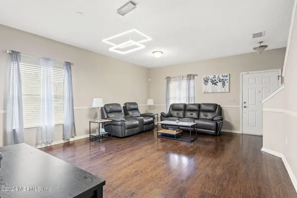 a living room with furniture and a wooden floor