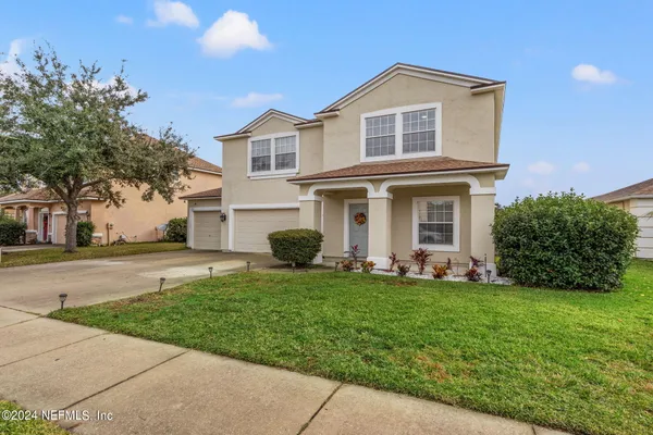 a front view of a house with a yard and garage