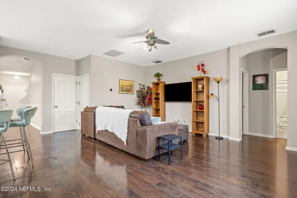 a living room with furniture a flat screen tv and a table