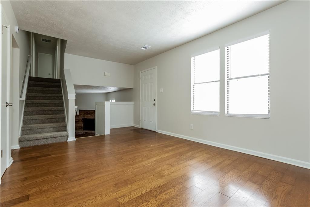 3352 Herrenhut Road Lithonia, GA 30038 - Photo 3 of 27 wooden floor in an empty room with a window