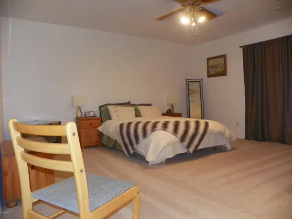 a bed sitting in a bedroom next to a chair and a chair