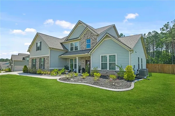 a front view of a house with a garden and patio