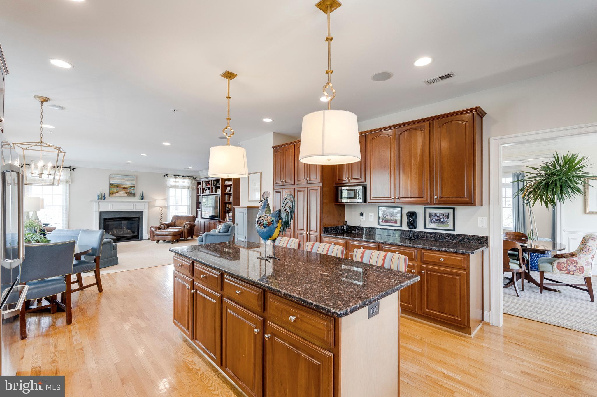 8502 Rayburn Road Bethesda, MD 20817 - Photo 17 of 49 a kitchen with granite countertop a stove a sink a dining table and chairs with wooden floor