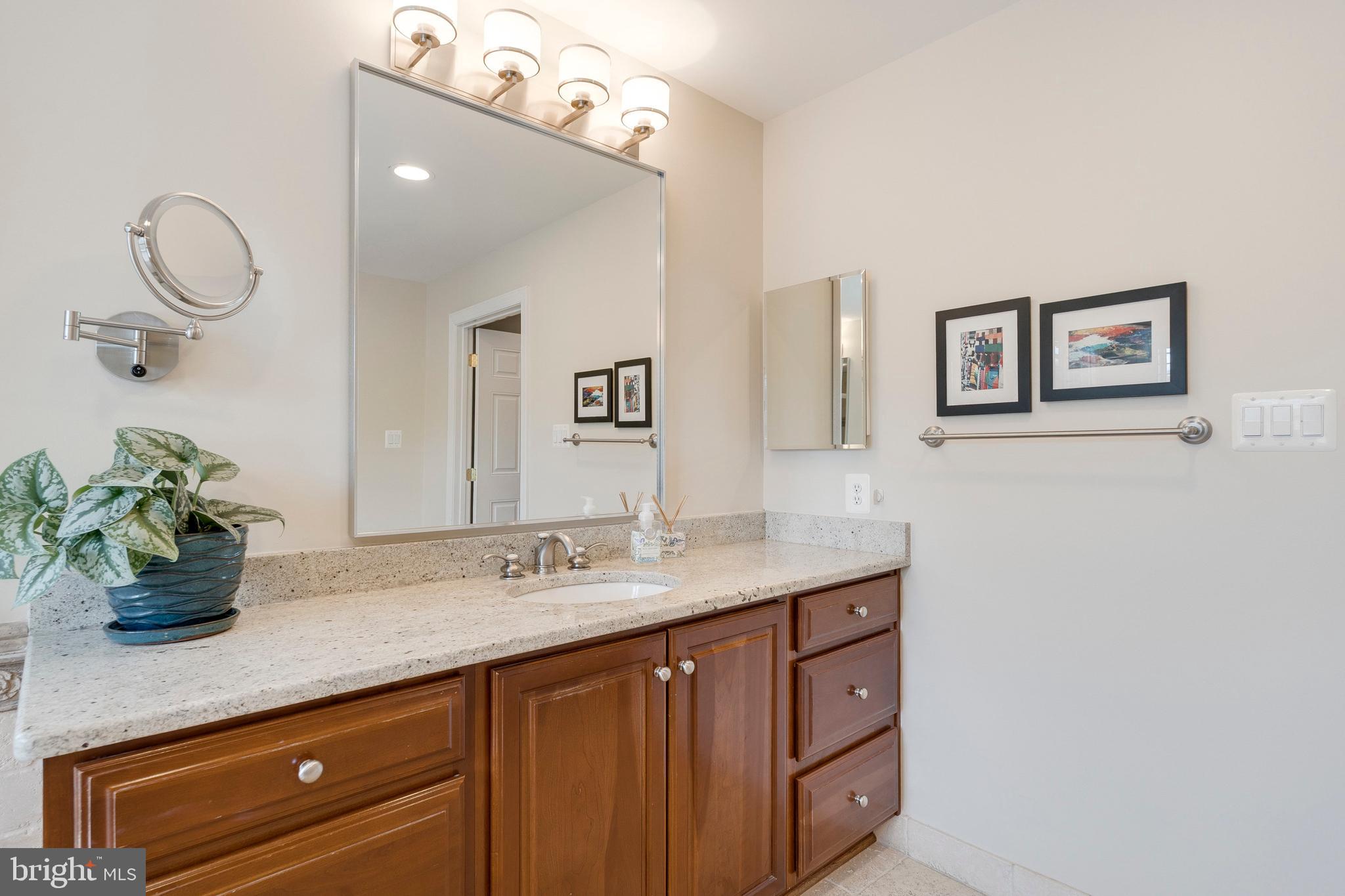 8502 Rayburn Road Bethesda, MD 20817 - Photo 26 of 49 a bathroom with a granite countertop sink a mirror and vanity