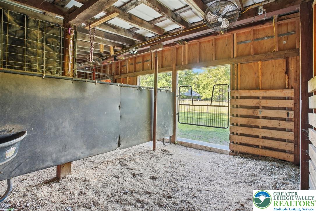9033 Loop Road Slatington, PA 18080 - Photo 43 of 53 A well-ventilated stable interior opens to a verdant outdoor pasture.