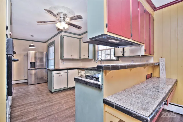 an empty room with wooden floor fan and windows