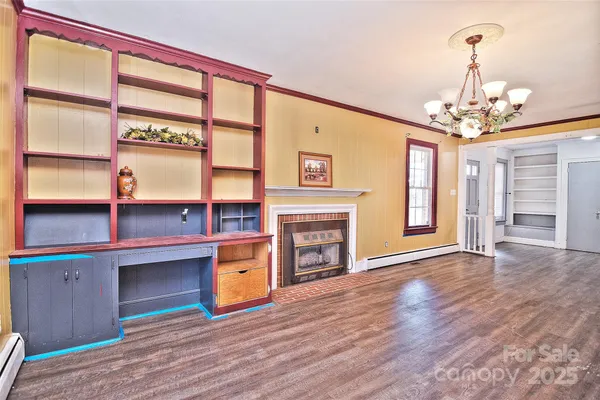 a view of a livingroom with a fireplace wooden floor and windows