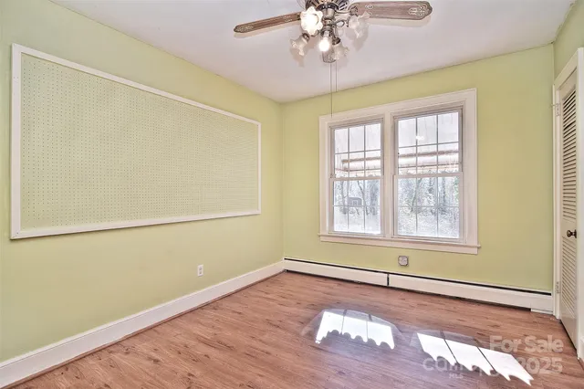 a view of a livingroom with wooden floor and a ceiling fan