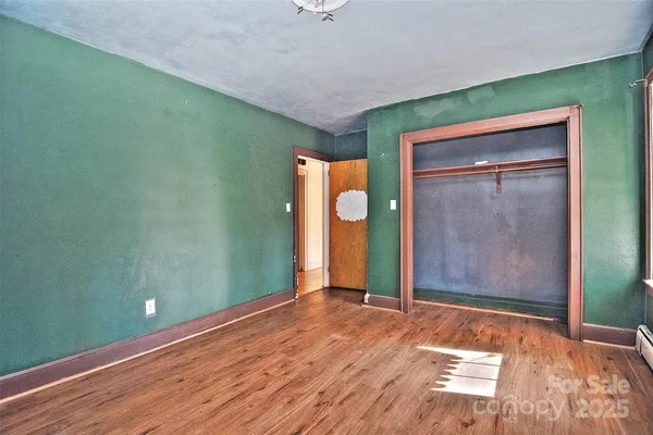 a view of a room with wooden floor and window