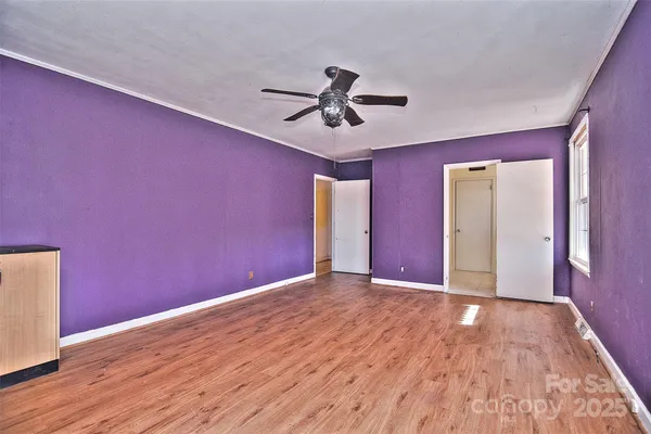 a view of empty room with wooden floor