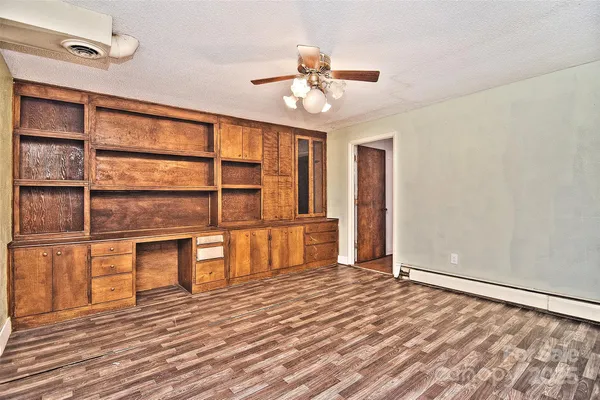 a view of a livingroom with wooden floor and a ceiling fan