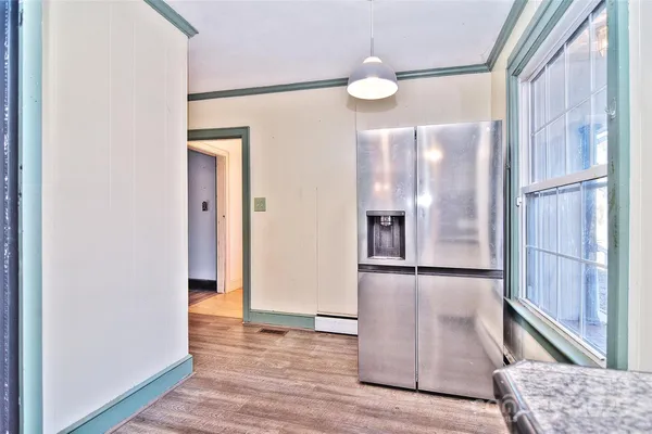 an empty room with wooden floor and a large window