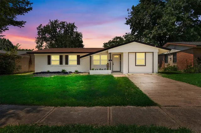 a front view of a house with a garden and yard