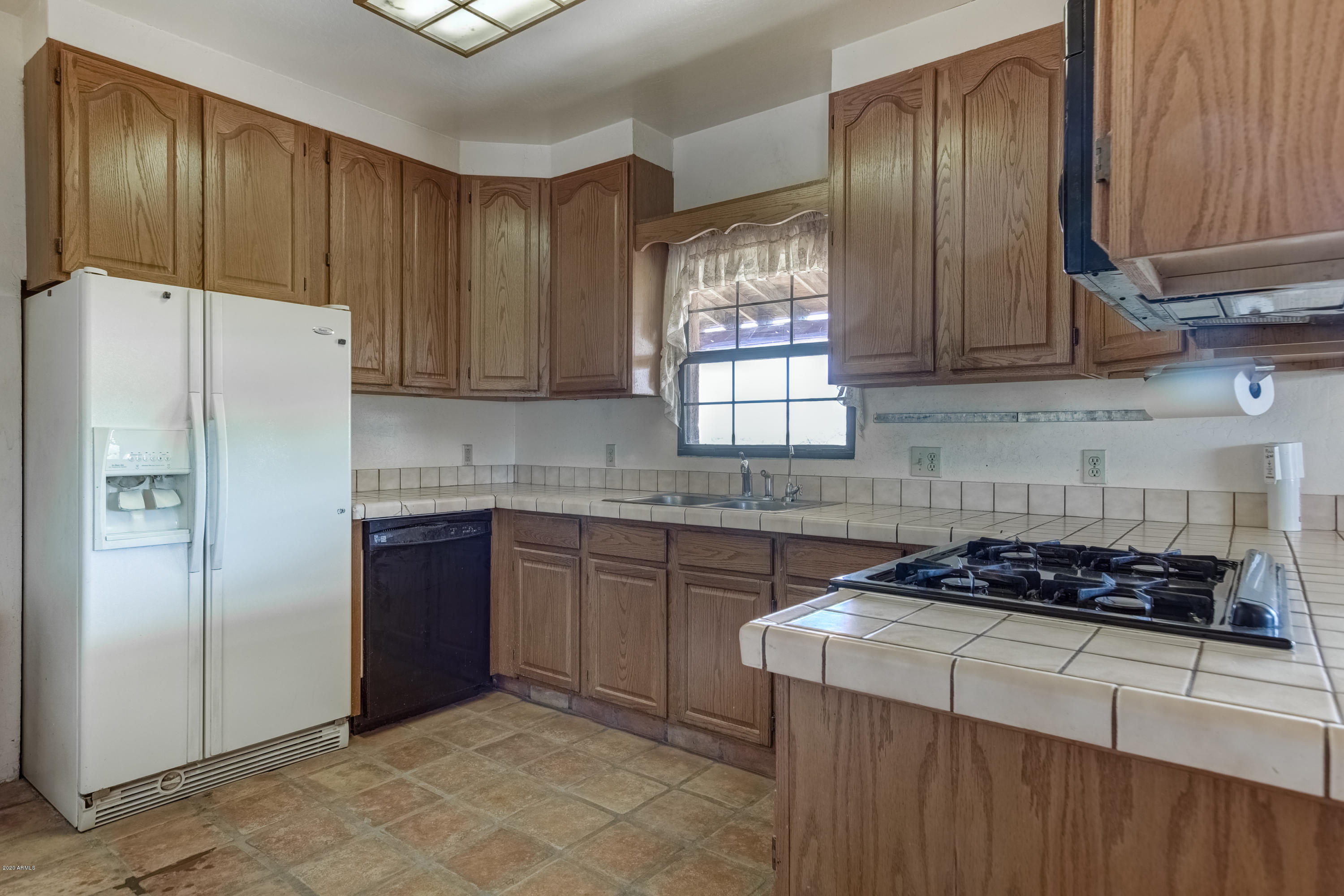 667 South Opal Road Maricopa, AZ 85139 - Photo 16 of 42 a kitchen with granite countertop stainless steel appliances a stove a refrigerator and cabinets