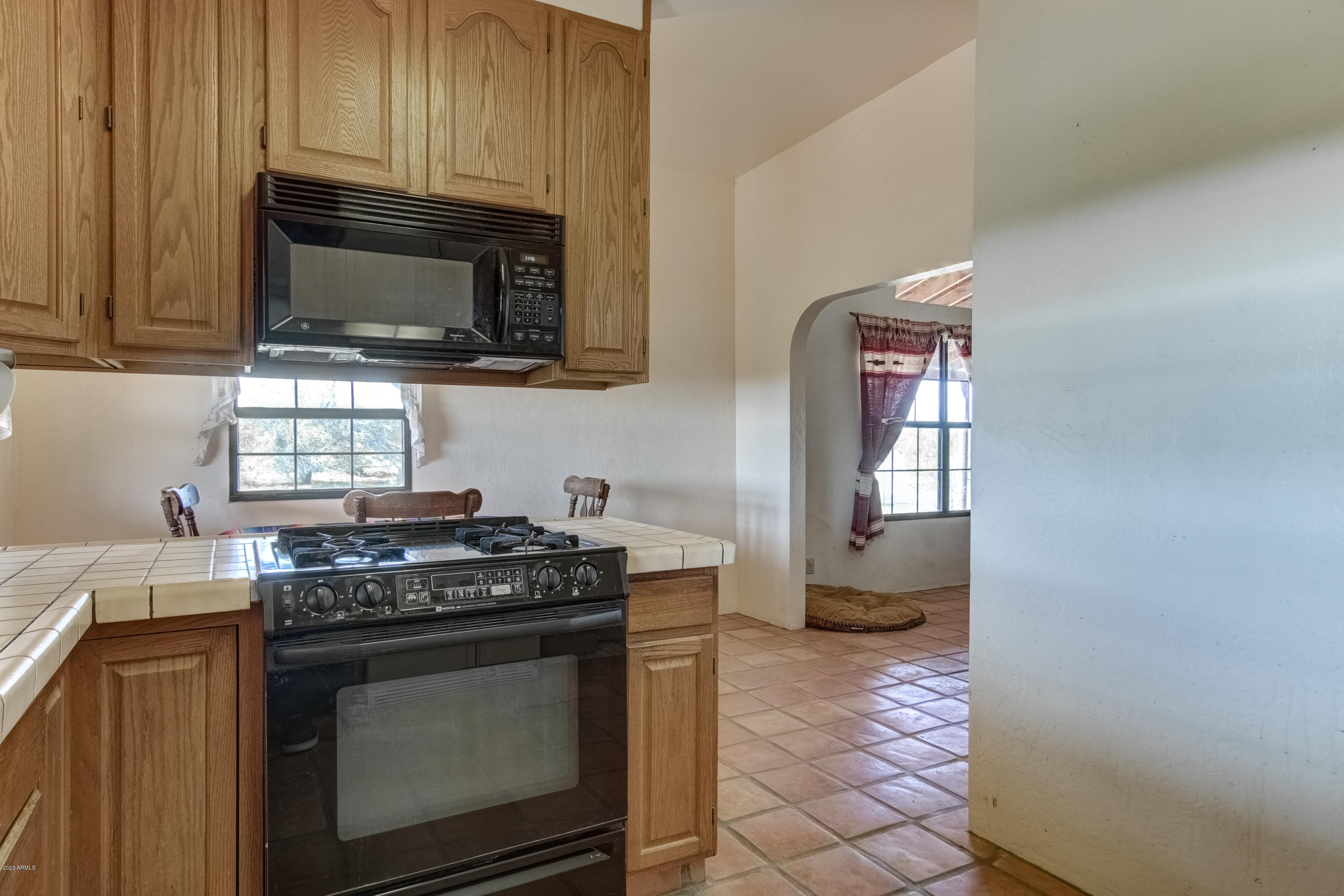 667 South Opal Road Maricopa, AZ 85139 - Photo 18 of 42 a kitchen with stainless steel appliances a stove a microwave a sink and cabinets