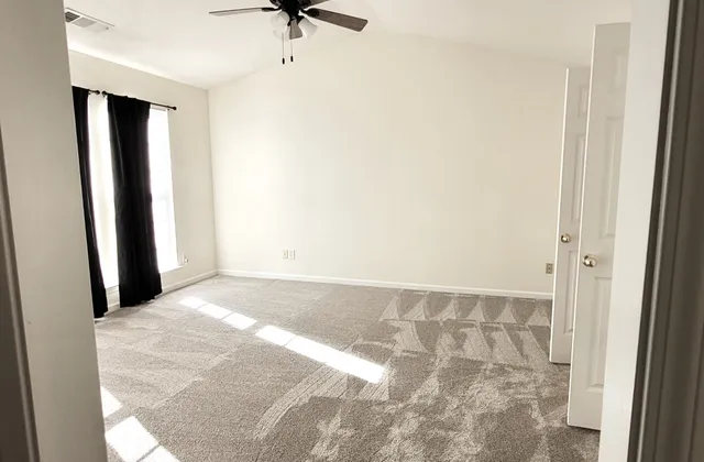 a view of a room with a ceiling fan and a window
