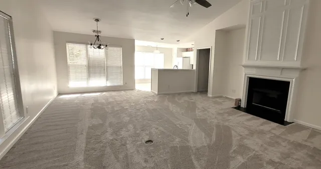 a view of an empty room with a fireplace and a window