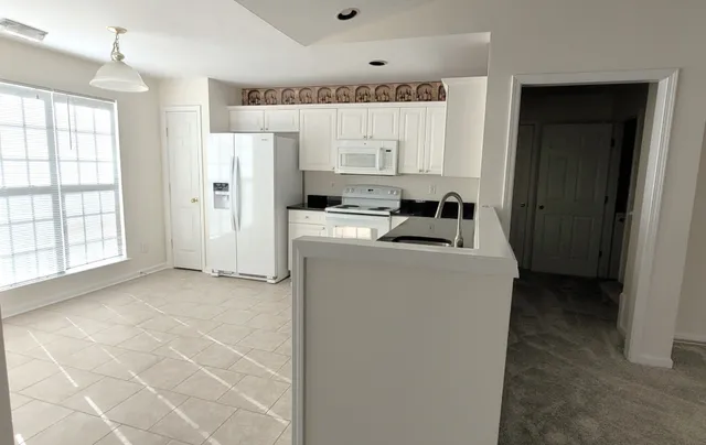 a kitchen that has a refrigerator and a window in it