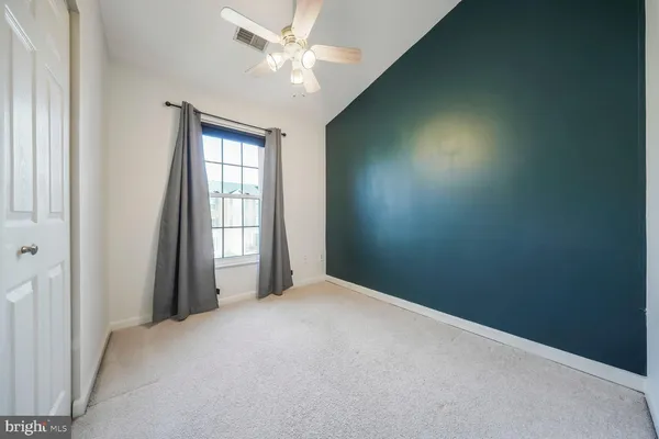 an empty room with windows and fan