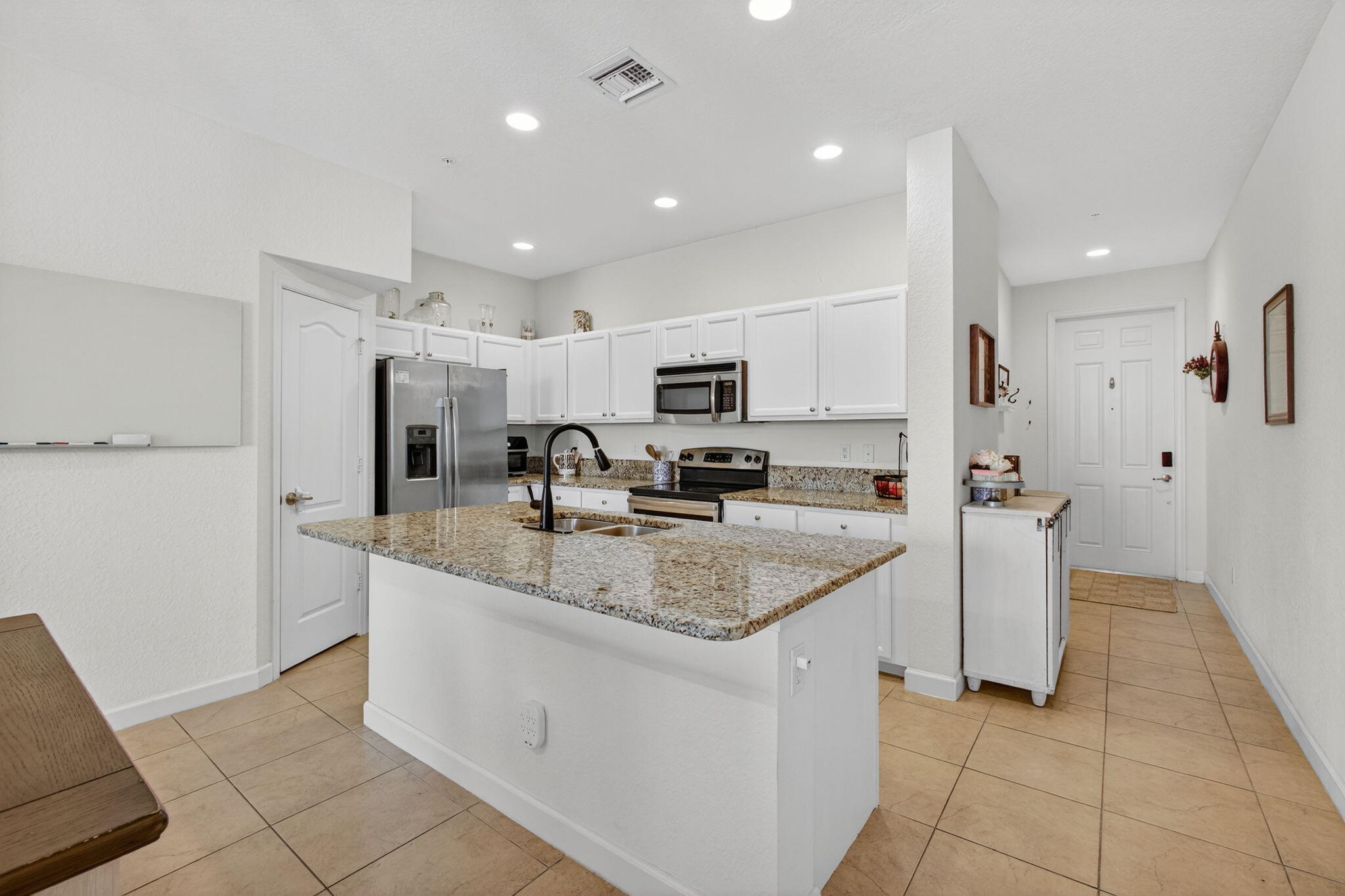 9440 Southwest Merlin Court Stuart, FL 34997 - Photo 13 of 54 a kitchen with stainless steel appliances granite countertop a sink and a stove