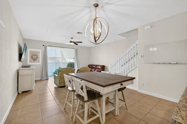 a kitchen with stainless steel appliances a white table chairs and a chandelier