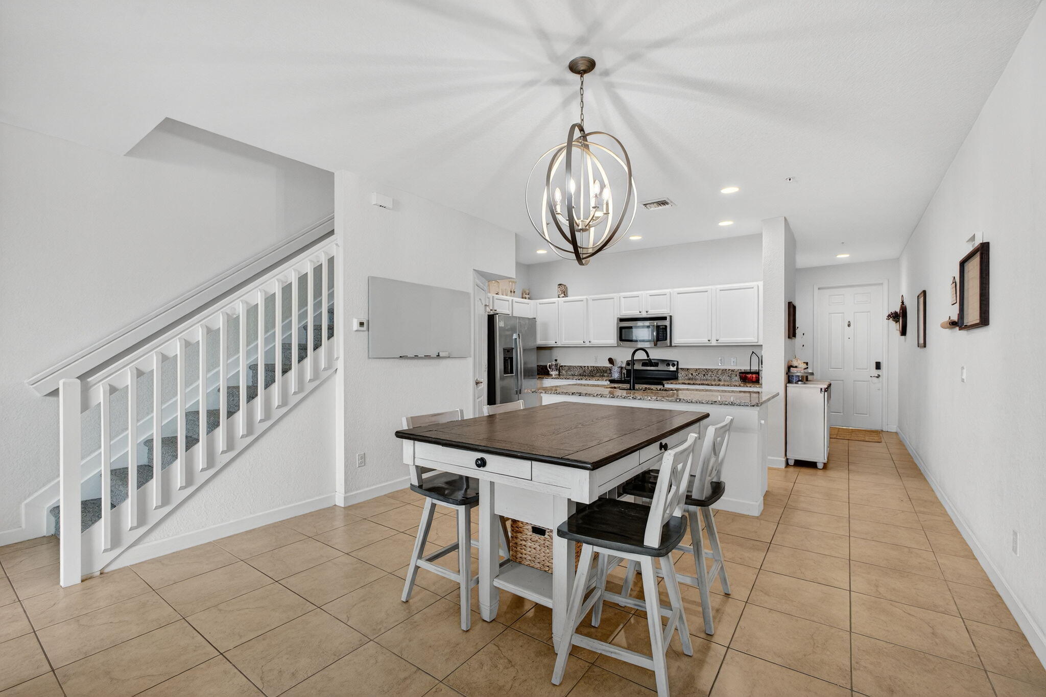 9440 Southwest Merlin Court Stuart, FL 34997 - Photo 15 of 54 a kitchen with stainless steel appliances a white table chairs and a chandelier