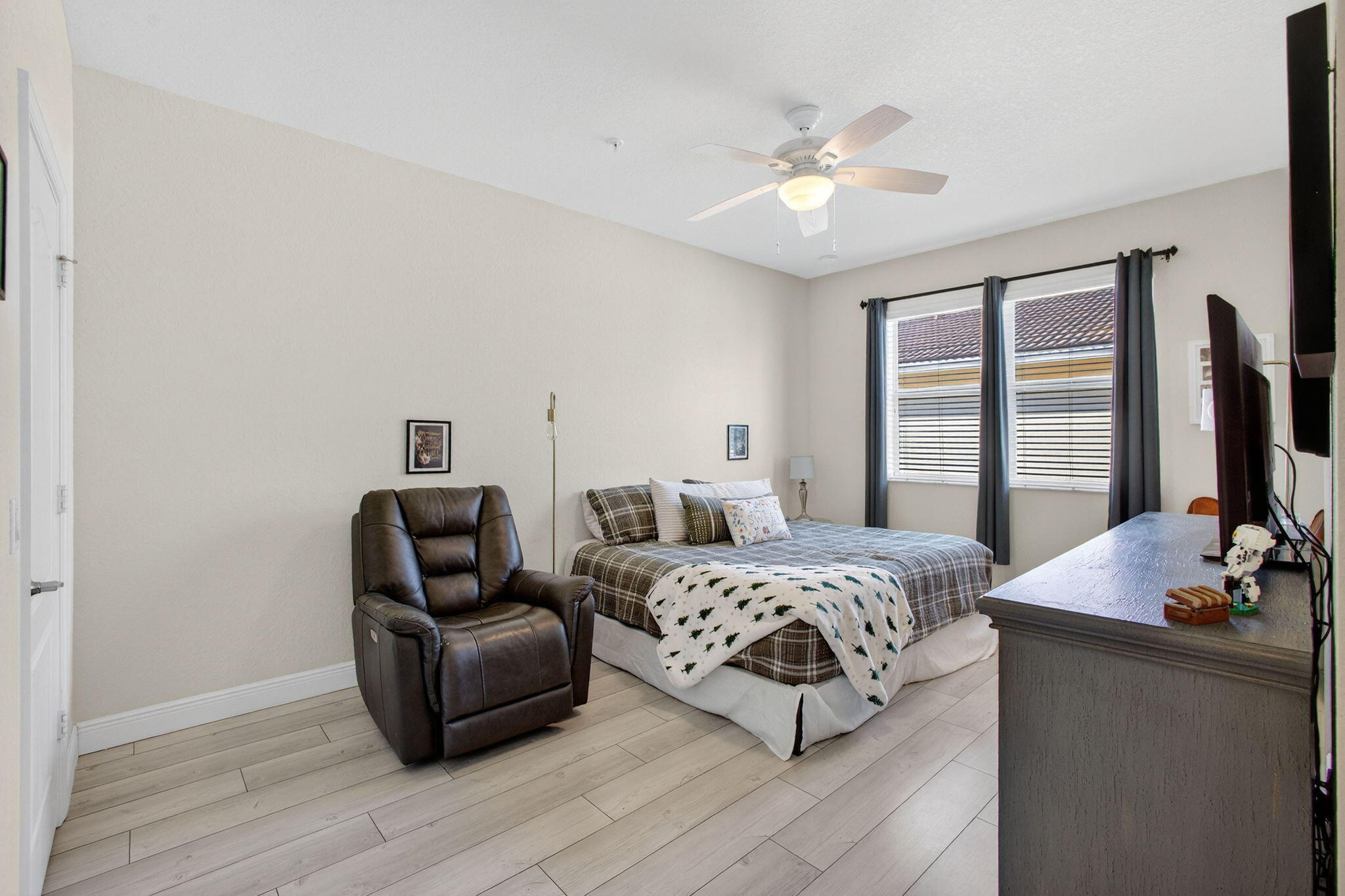 9440 Southwest Merlin Court Stuart, FL 34997 - Photo 23 of 54 a bedroom with a bed and a flat screen tv