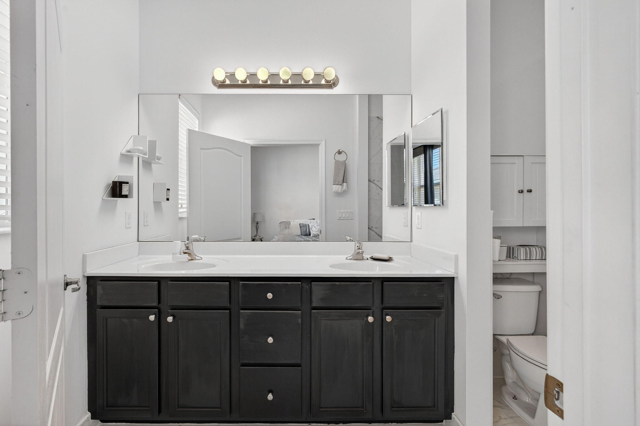 9440 Southwest Merlin Court Stuart, FL 34997 - Photo 29 of 54 a bathroom with double sink and a mirror