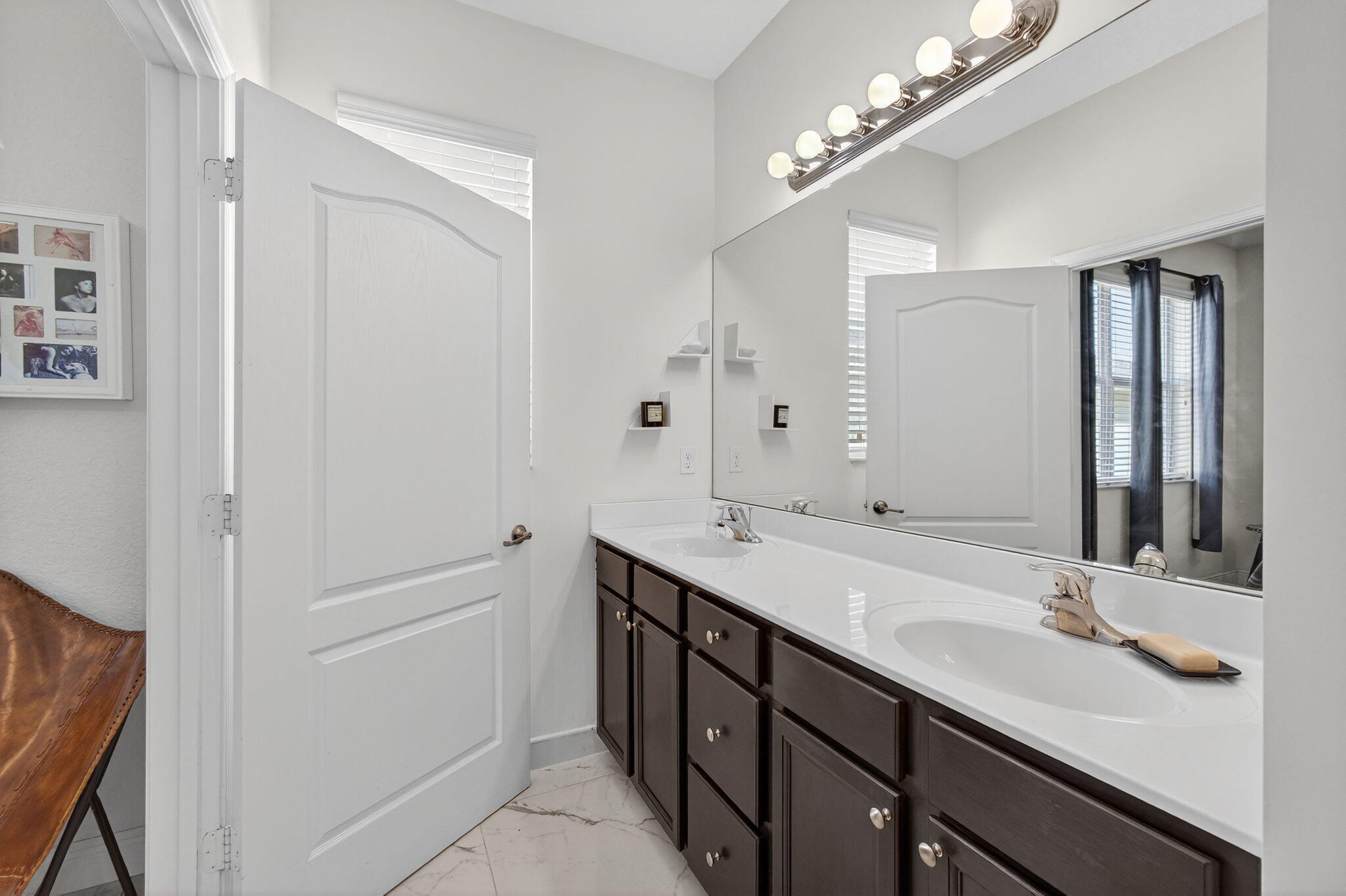 9440 Southwest Merlin Court Stuart, FL 34997 - Photo 30 of 54 a bathroom with a sink double vanity and a mirror