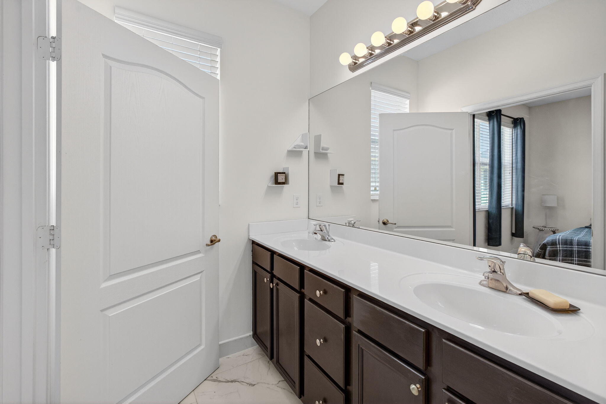 9440 Southwest Merlin Court Stuart, FL 34997 - Photo 31 of 54 a bathroom with a double vanity sink a and mirror