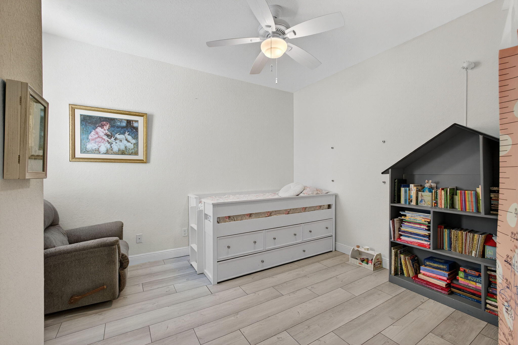 9440 Southwest Merlin Court Stuart, FL 34997 - Photo 38 of 54 a living room with furniture and a bookshelf