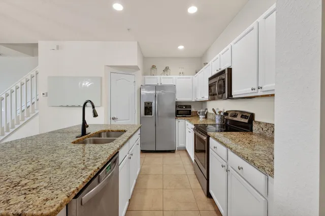 a kitchen with stainless steel appliances granite countertop a refrigerator sink and stove