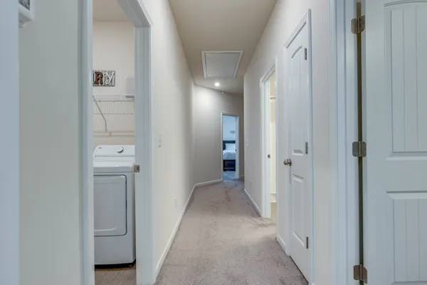 a view of a hallway with closet and a bathroom