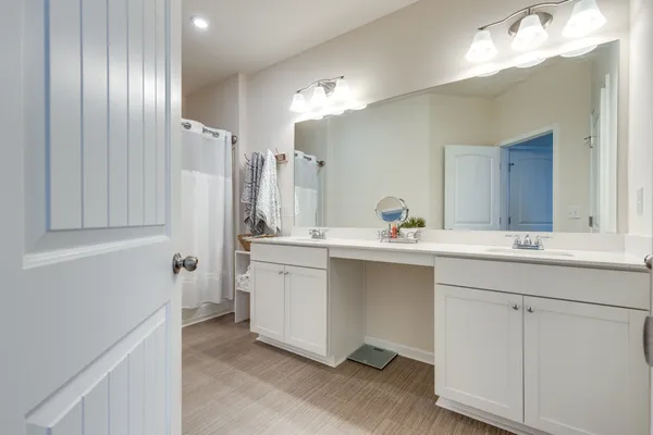 a bathroom with a double vanity sink a mirror and a shower