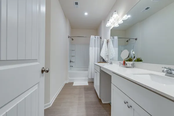 a bathroom with a sink double vanity granite tub and shower