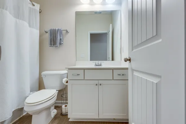 a bathroom with a sink vanity mirror and toilet