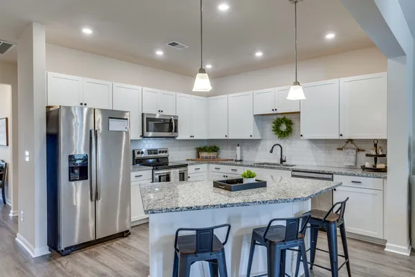 a kitchen with granite countertop a center island and stainless steel appliances