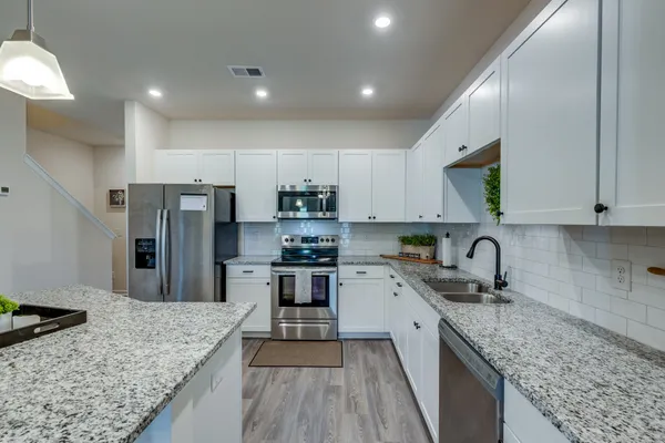 a kitchen with stainless steel appliances granite countertop a sink stove and refrigerator