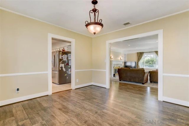 a view of empty room with window and wooden floor